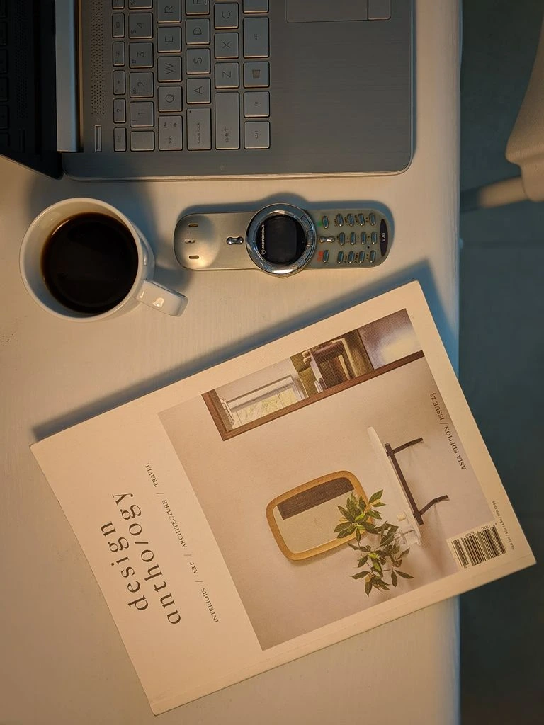 An open notebook on a reading desk, photographed in near-monochrome with a warm wash.
